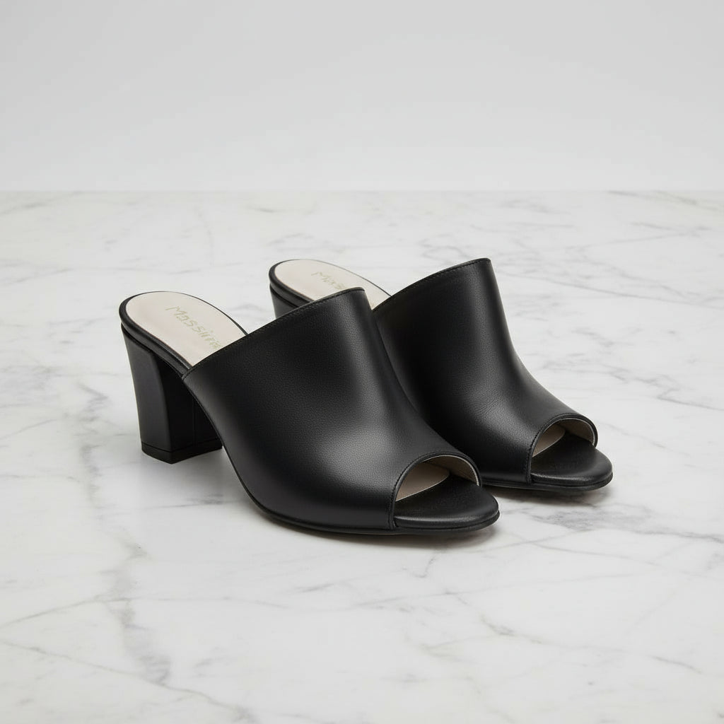 Black open-toe heeled sandals on a marble surface