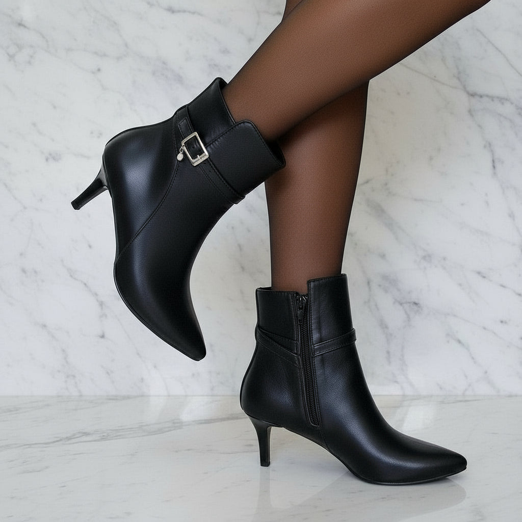 Black high-heeled ankle boots on a marble background