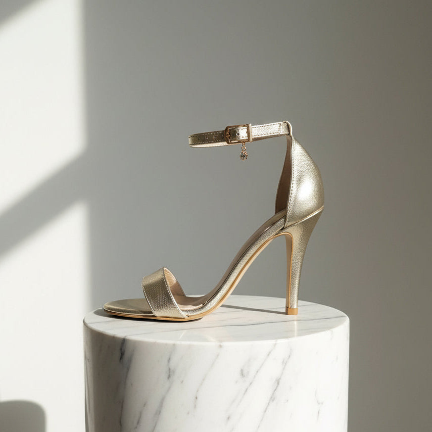 Light gold leather high heel sandals with ankle strap on marble surface