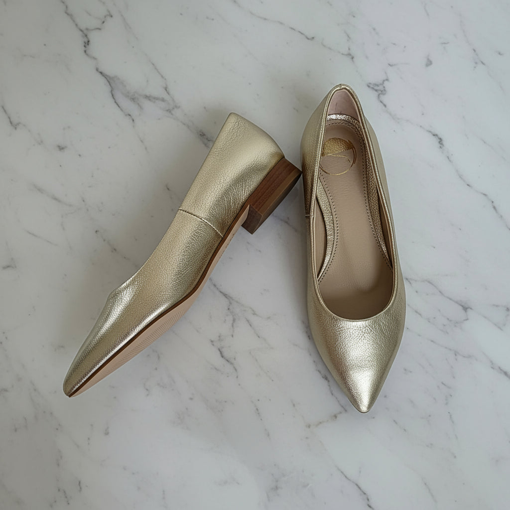 Side and top flat lay of petite small size gold leather ballerinas with pointed toes.
