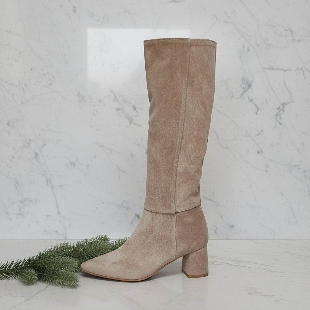Beige knee-high boot on a marble background