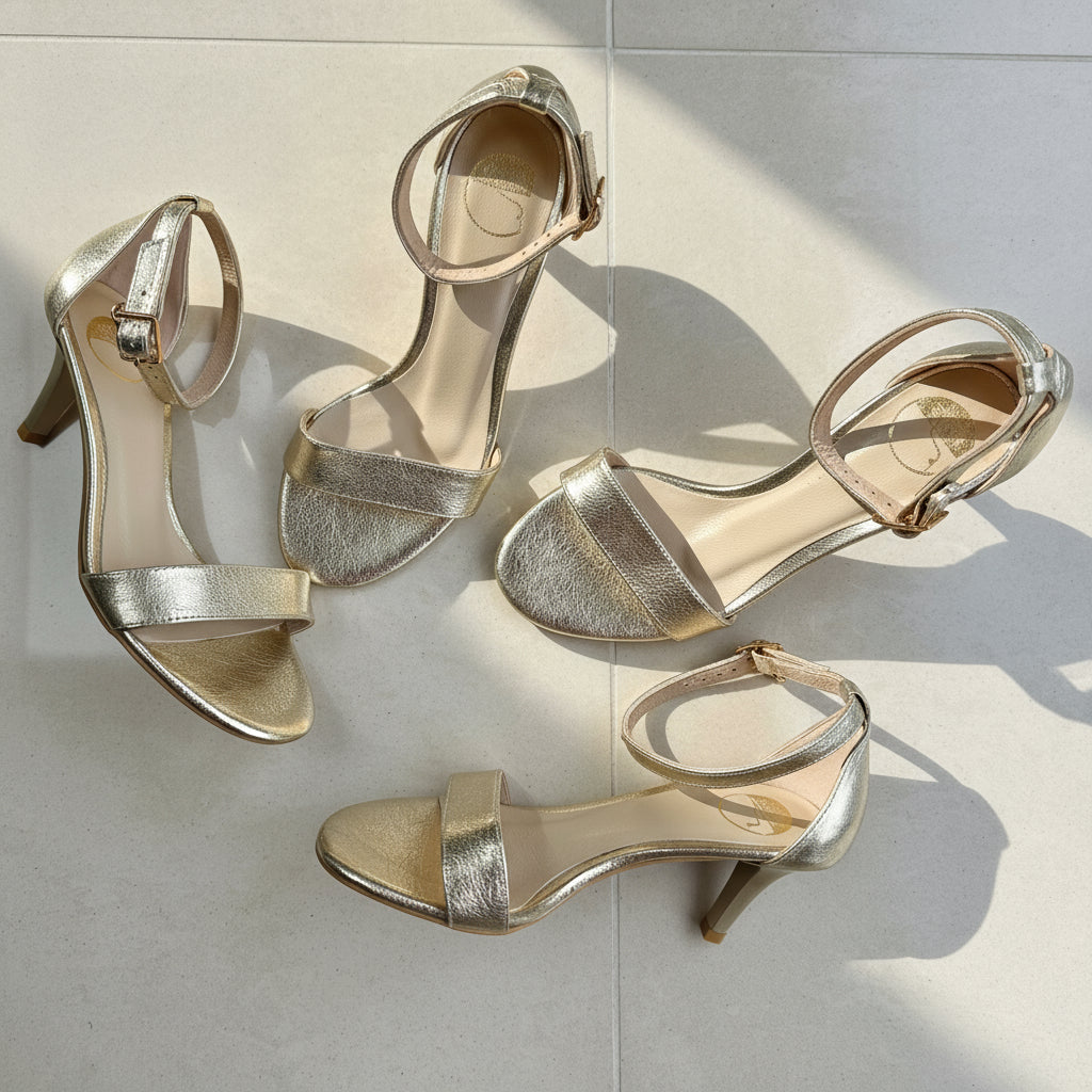 Top view of light gold petite small size women's kitten heels with ankle straps on marble,