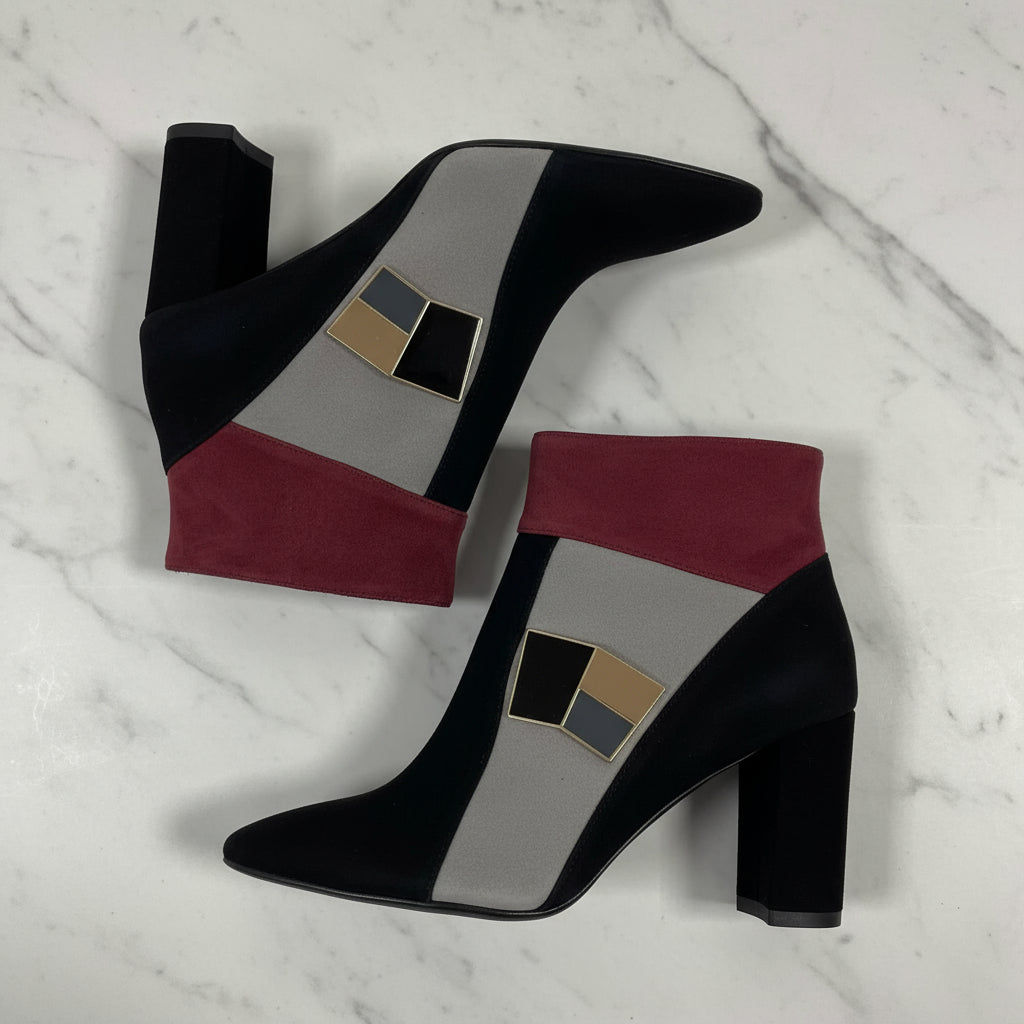 Black high-heeled boots with geometric pattern on a marble surface