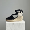 Black wedge sandal with espadrille sole on a gray background