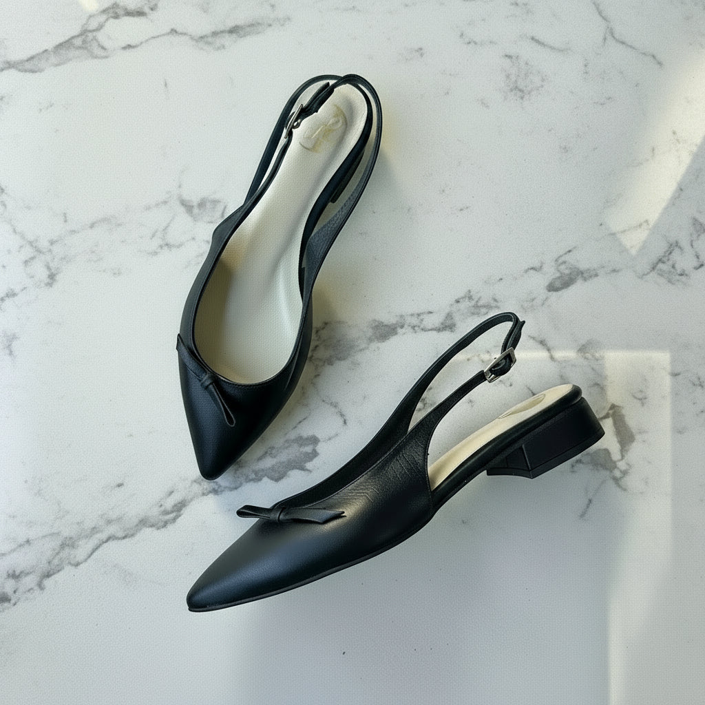 Black slingback shoes on a marble surface