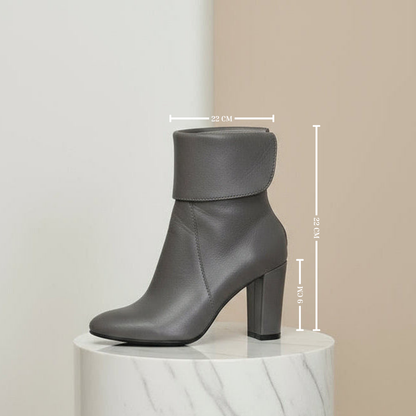Gray ankle boot on a white pedestal with measurements indicated