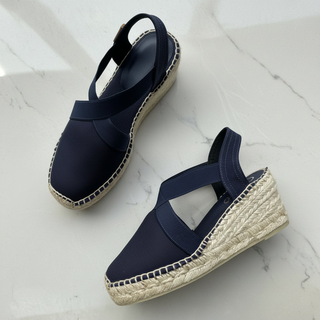 Navy blue espadrille wedge sandals on a light gray background