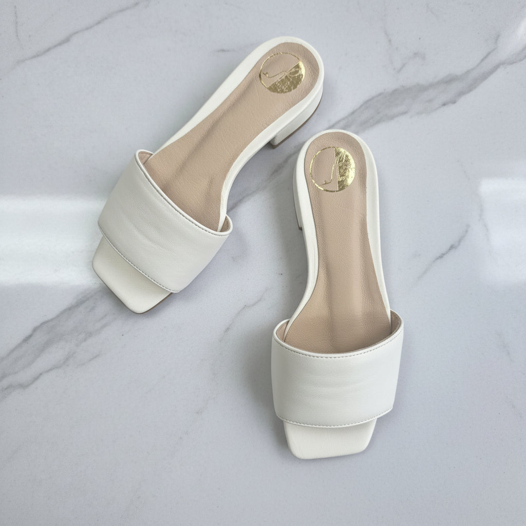 Pair of white sandals on a marble surface
