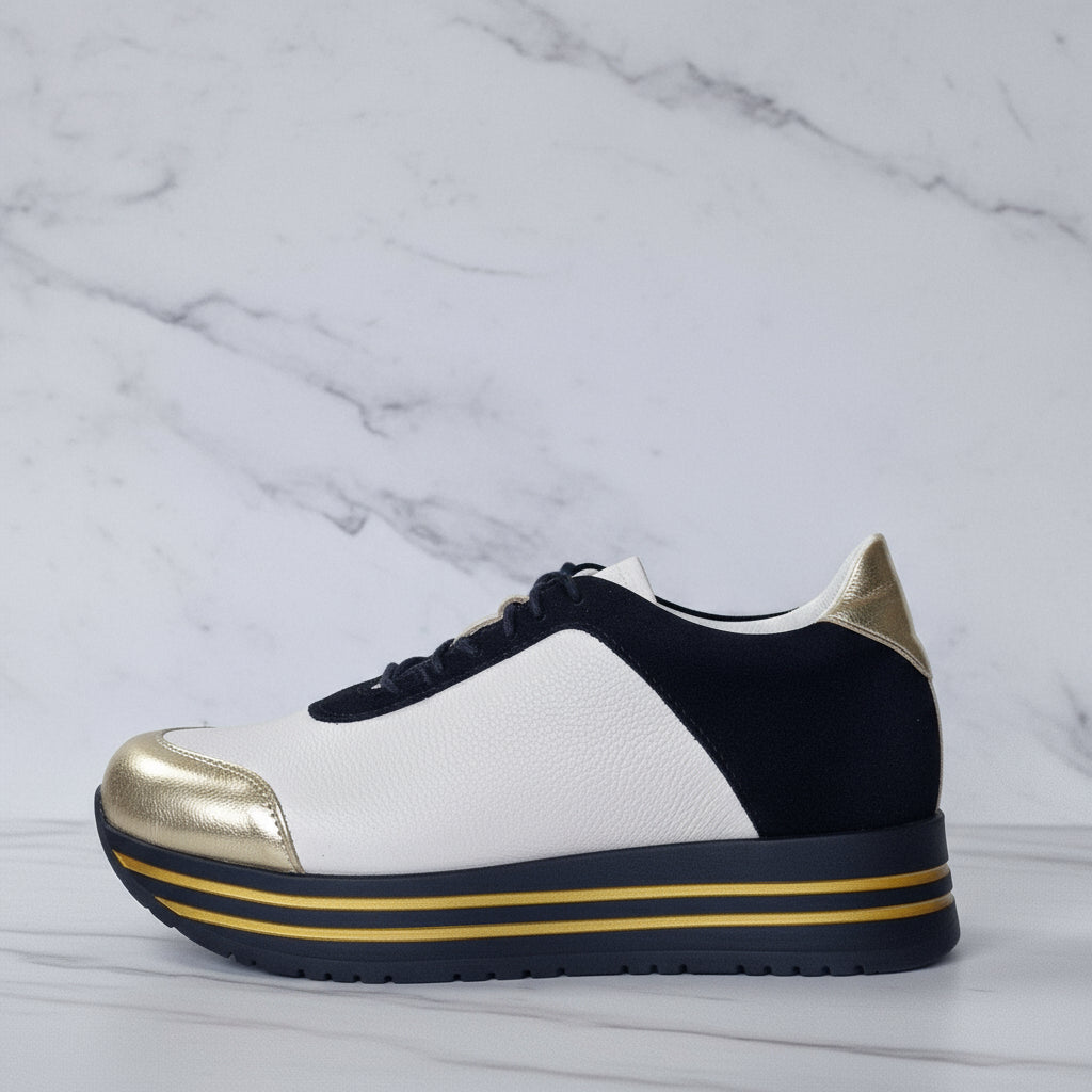 Sneaker with gold and black accents on a marble background