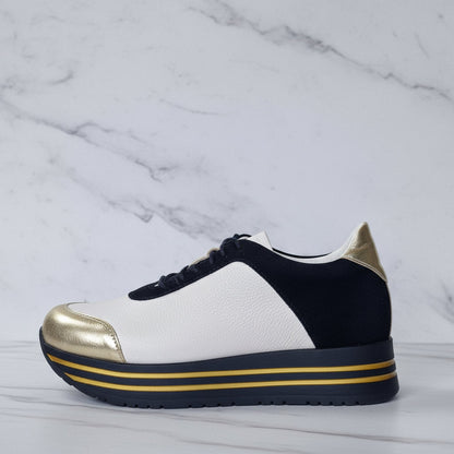 Sneaker with gold and black accents on a marble background
