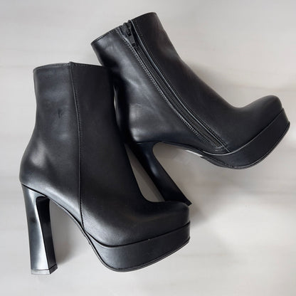 Black leather ankle boots set on a platform and high geometric heel