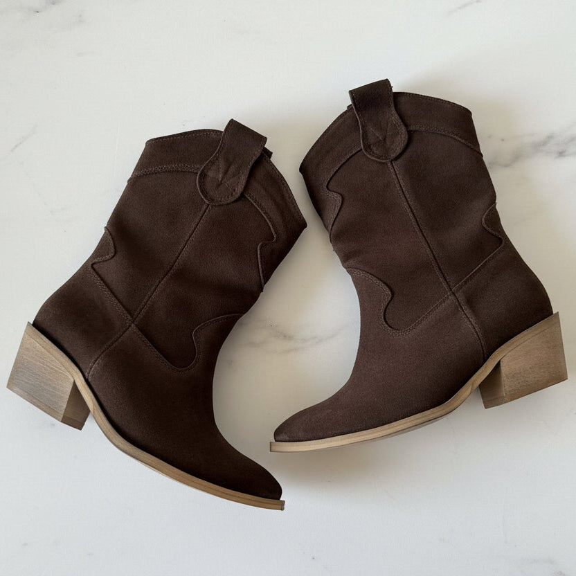 Pair of brown suede ankle boots on a white background