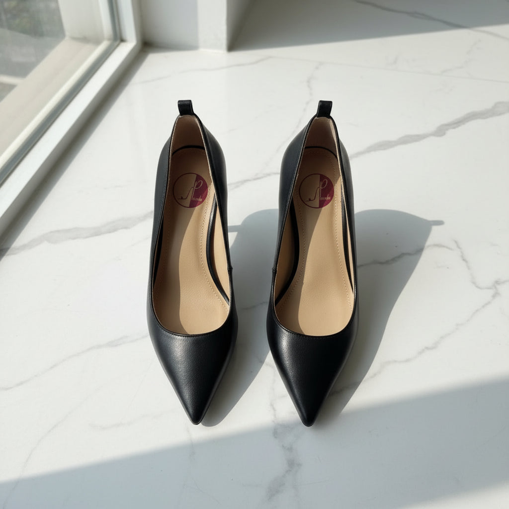 Pair of black high-heeled shoes on a marble surface