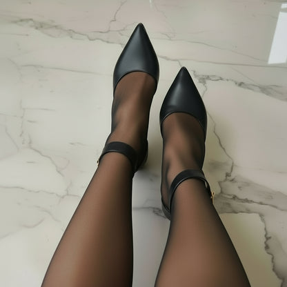 Woman wearing pointed toe ankle strap shoes in black leather