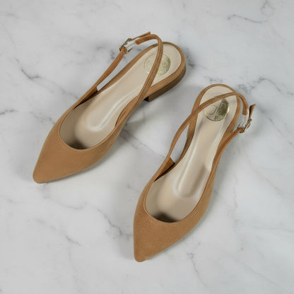 Top view of petite tan suede slingback pointed toe women’s shoes on marble surface with green plant.