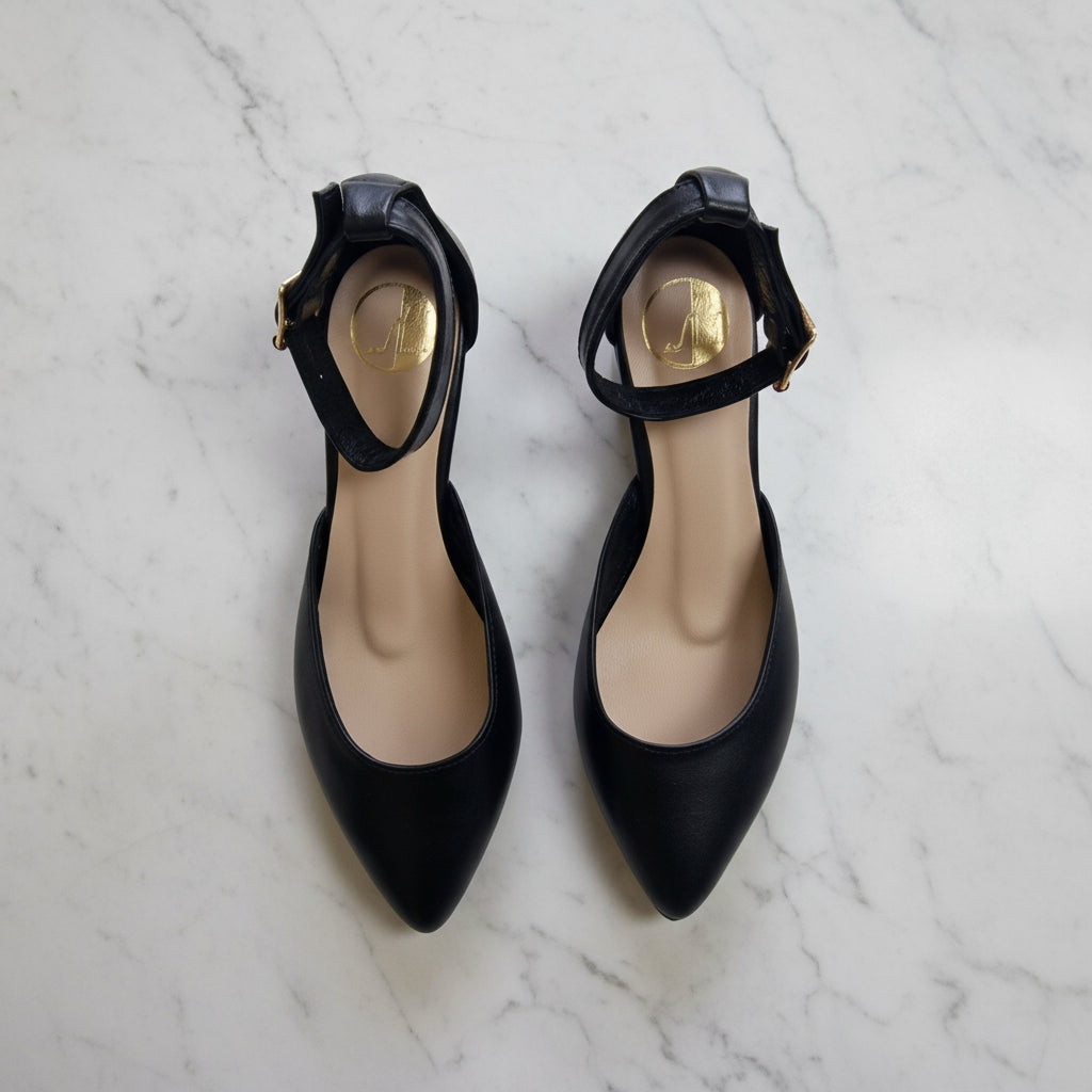 Pointed toe court heels in black leather with an ankle strap