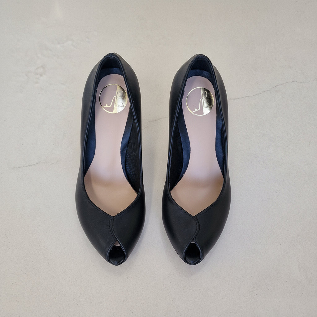 Pair of black high-heeled shoes with open toes on a light gray background