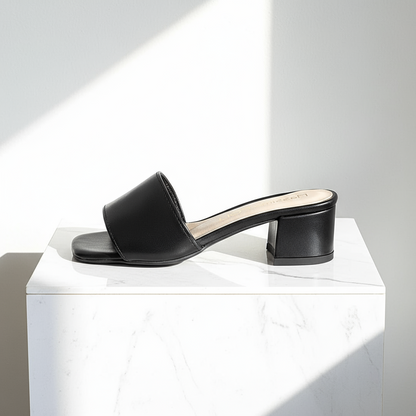 Pair of black leather ROBIN sandals with 4CM block heel on marble surface.