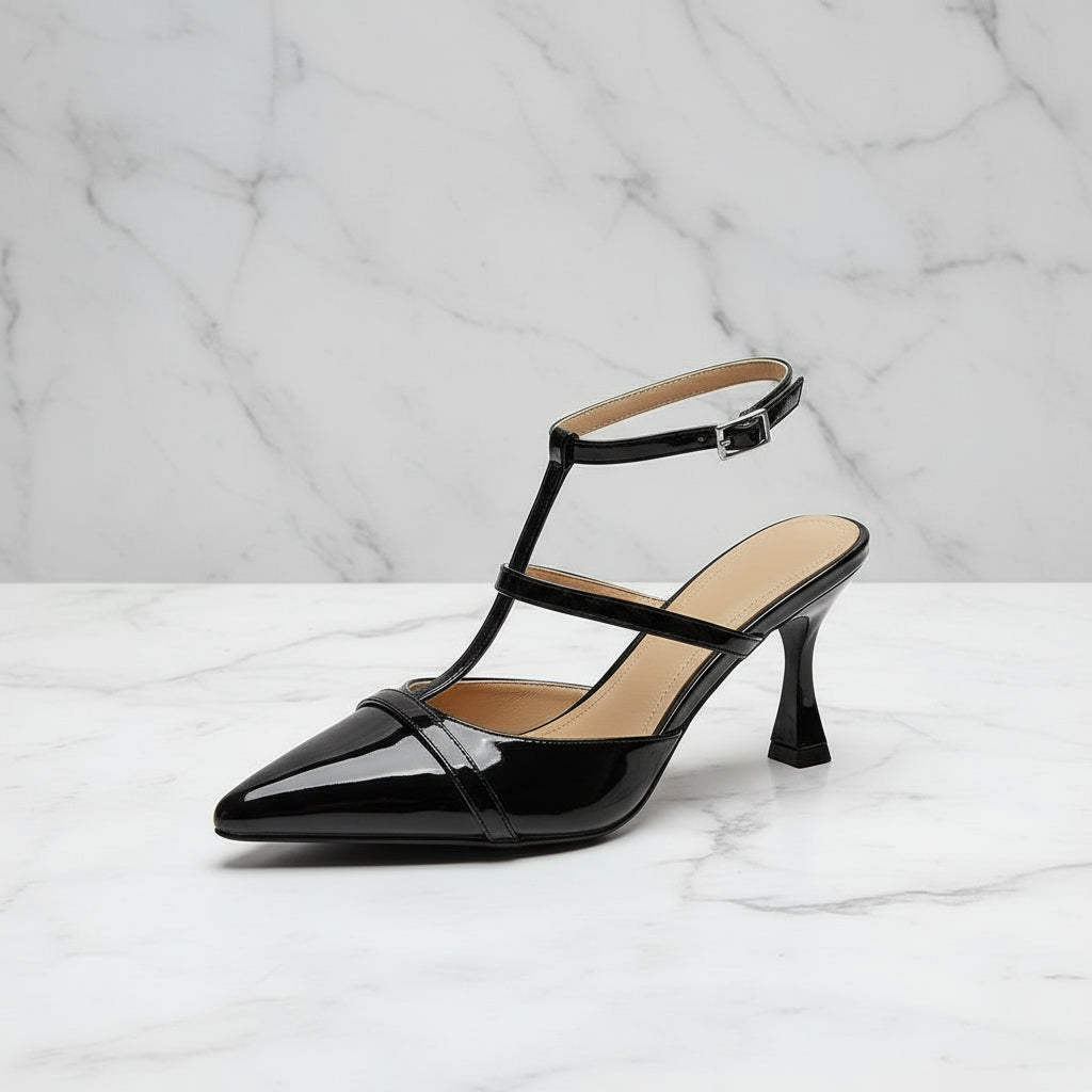 Black high-heeled shoe with a strap on a marble background
