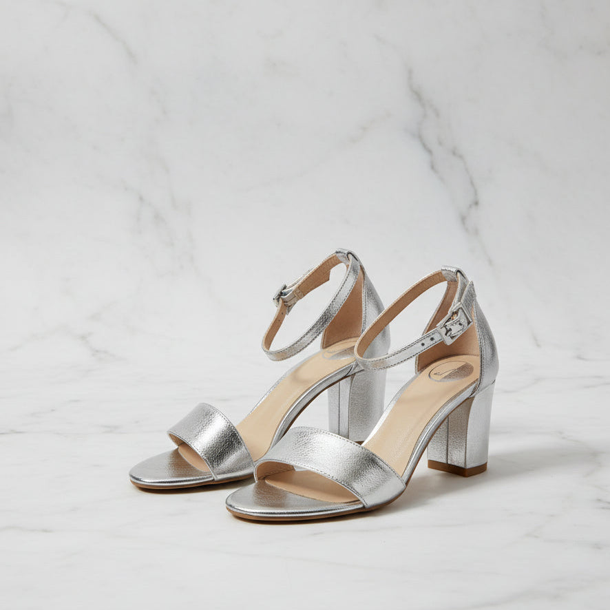 Silver high-heeled sandals on a light gray background