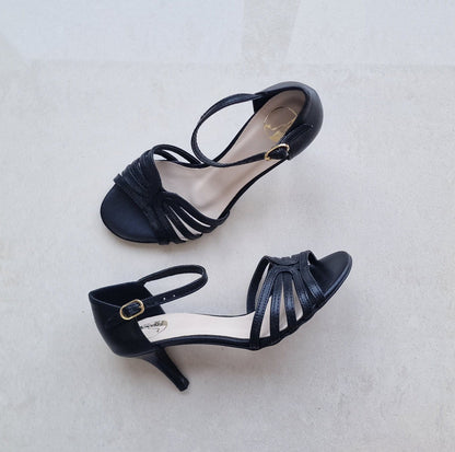 Pair of black high-heeled shoes on a light gray background