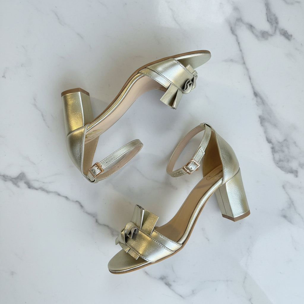 Gold high-heeled shoes on a marble background