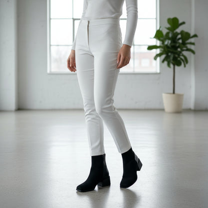 Model wearing TATE petite black ankle boots with 5cm heel, styled with white slim trousers.