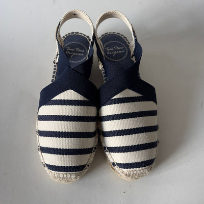 Pair of navy and white striped espadrilles on a light gray background