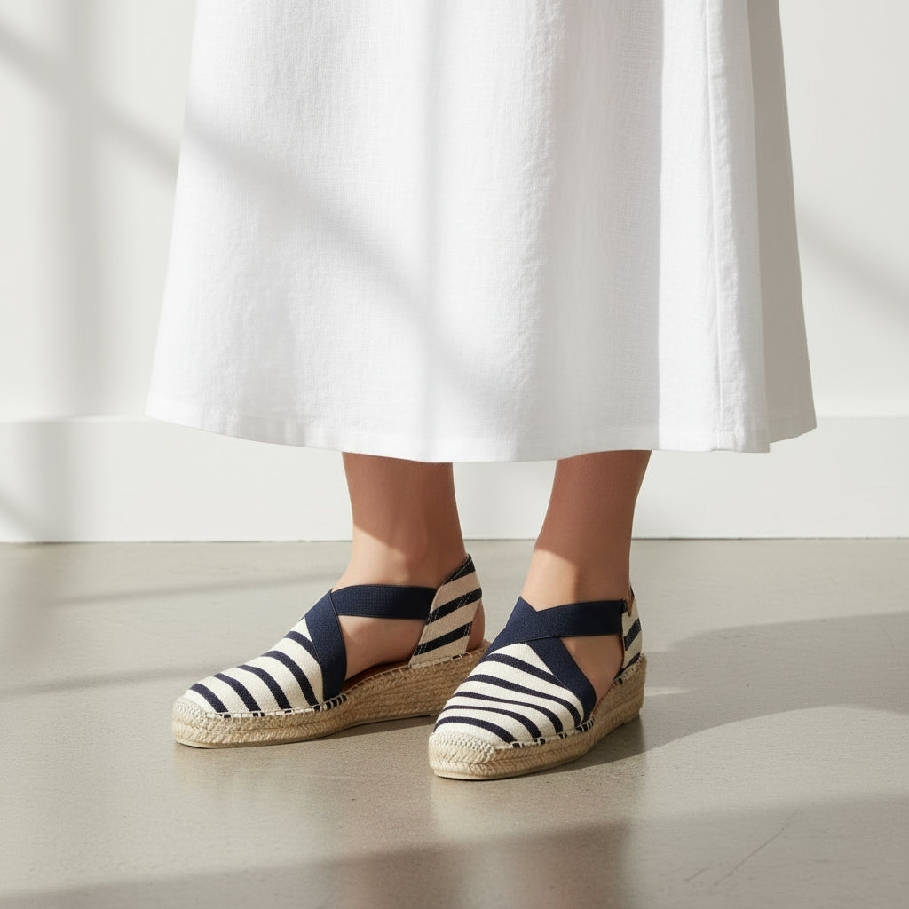 Woman in a white dress standing on a balcony with ocean view