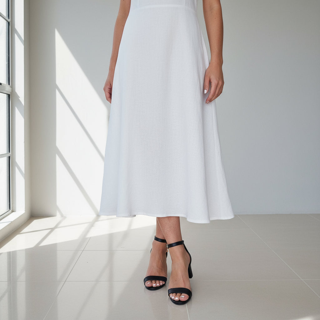 TRINITY black leather heels with ankle strap on model, minimalist design for small feet sizes on marble background