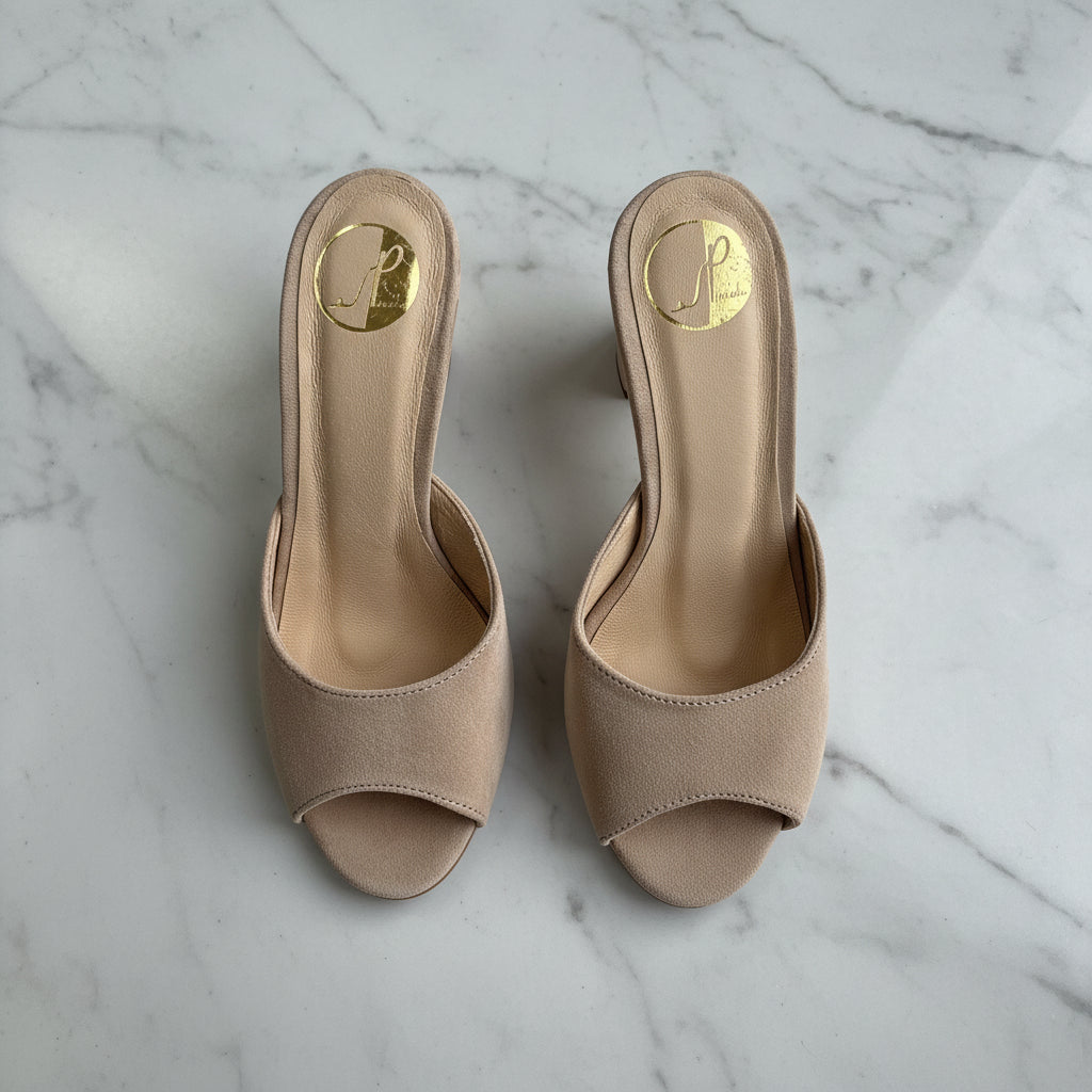 Pair of beige open-toe high-heeled shoes on a light gray background