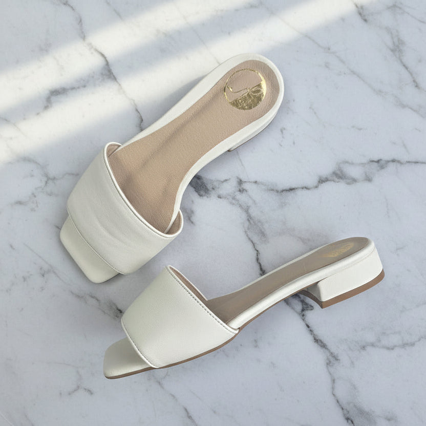 Pair of white sandals on a marble surface