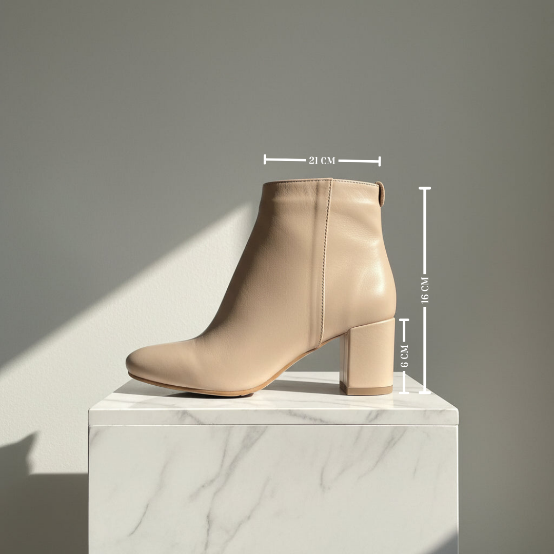 A beige leather ankle boot with a block heel, shown on a white marble pedestal with dimension lines indicating measurements of 21 cm width, 16 cm height, and 6 cm heel depth against a gray background.