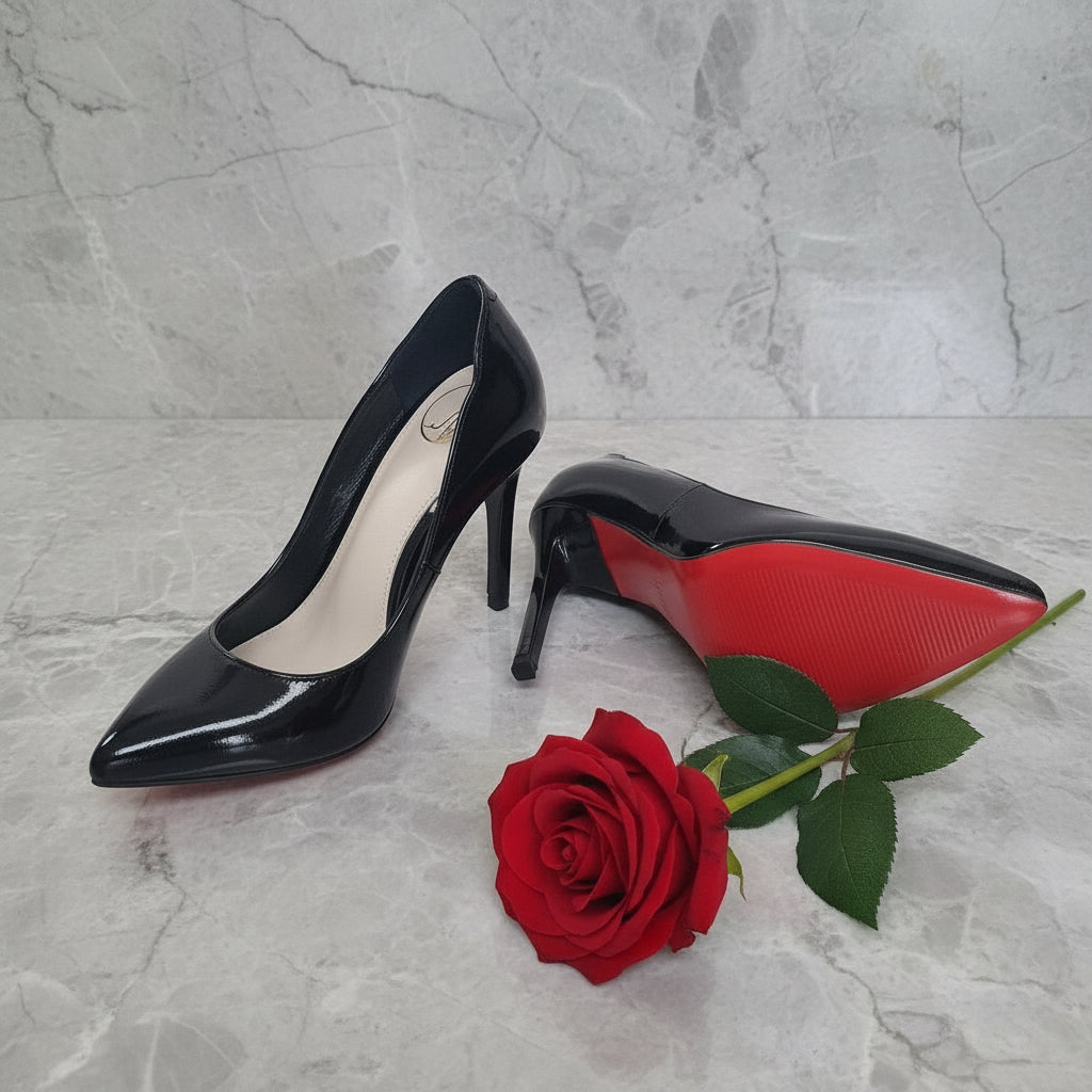 Black high-heeled shoes with red soles on a light gray floor.
