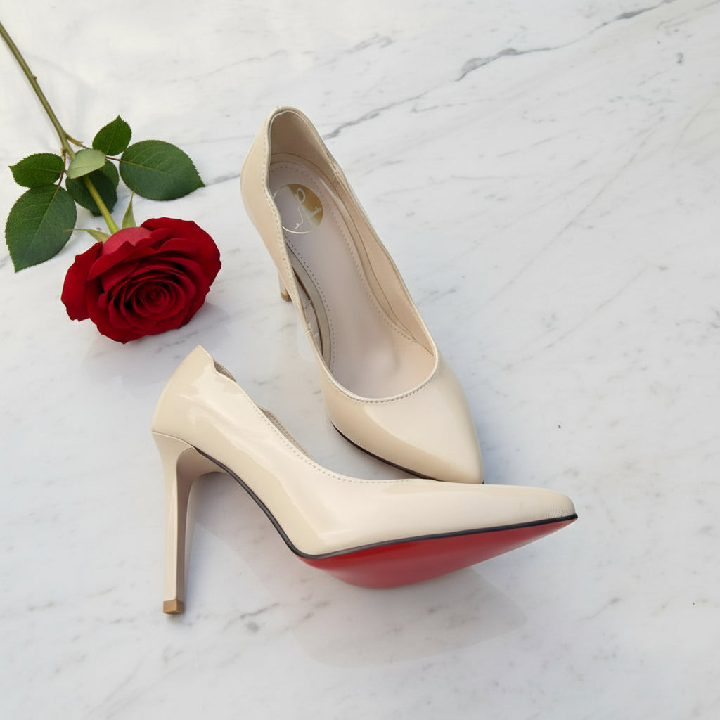 Flatlay of VOID nude patent pumps showing standout red sole and pointed toe.