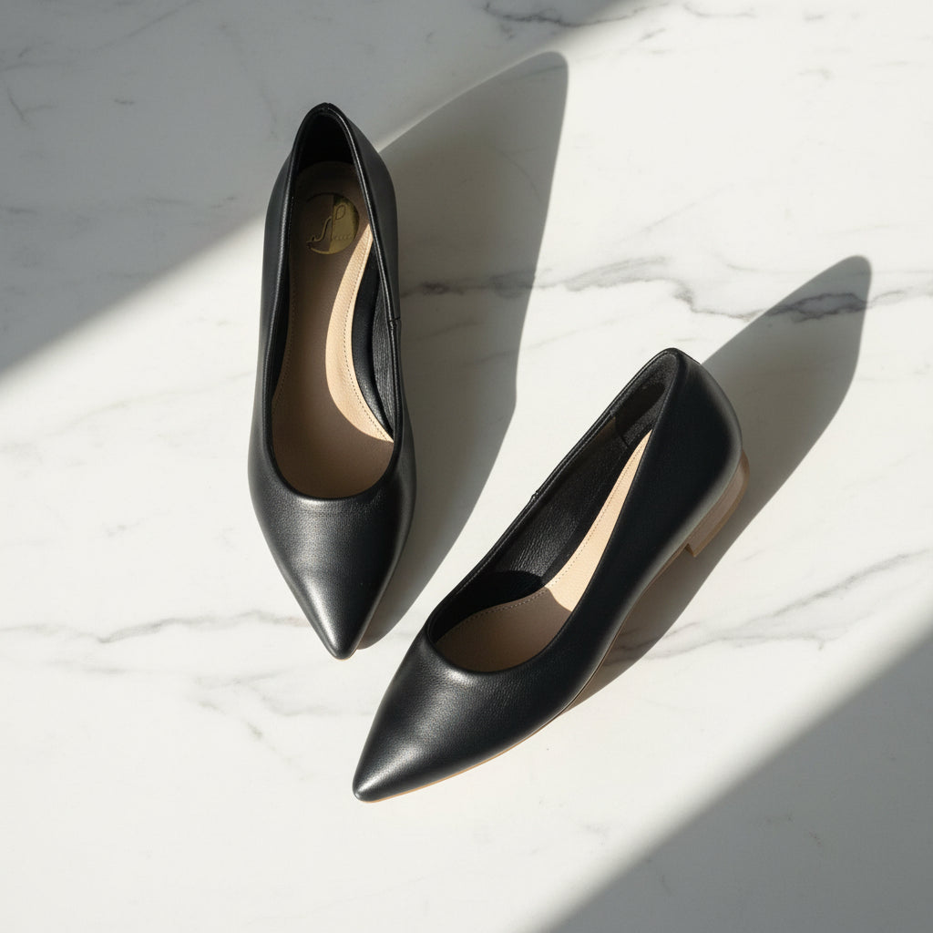 Black high-heeled shoes on a marble surface