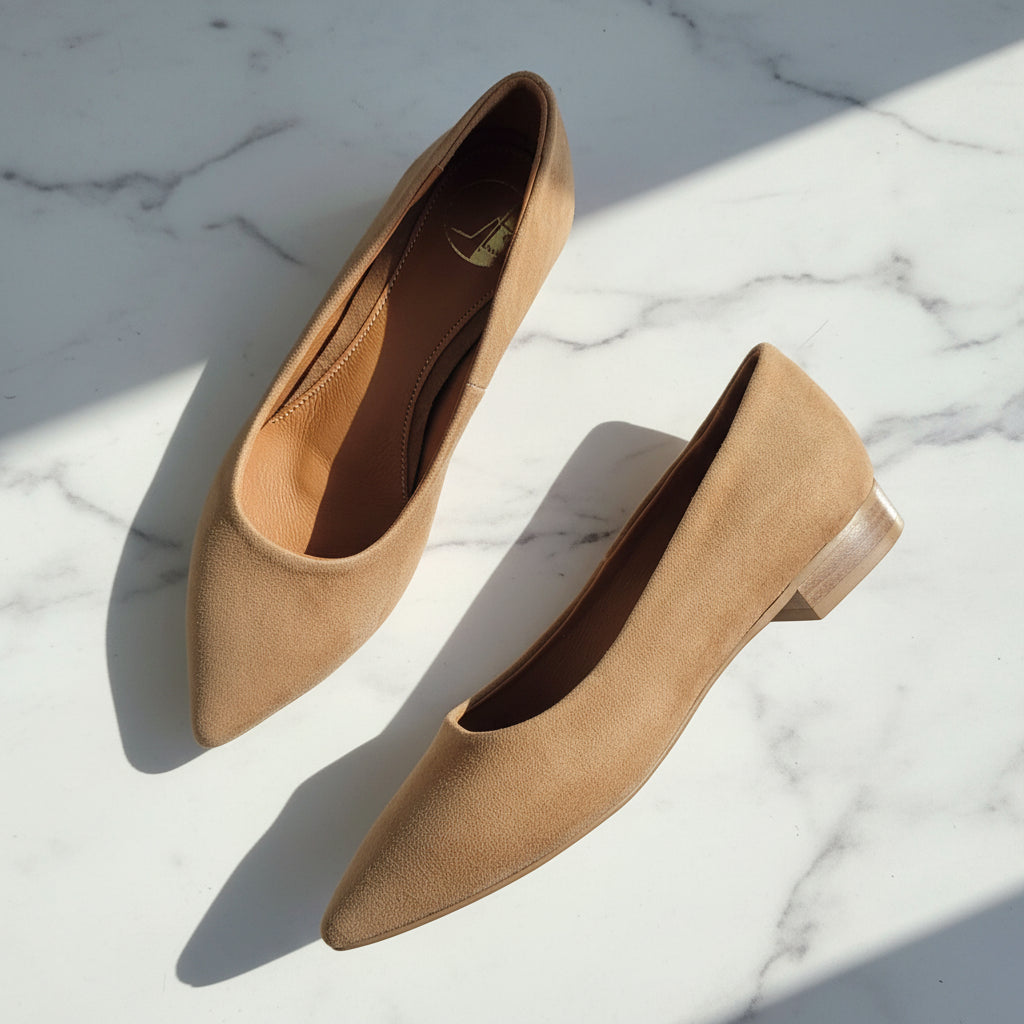 Pair of tan pointed-toe shoes on a marble surface