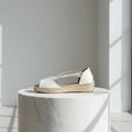 Side profile of tan leather espadrille sandal featuring woven jute sole and crisscross elastic straps for small feet.