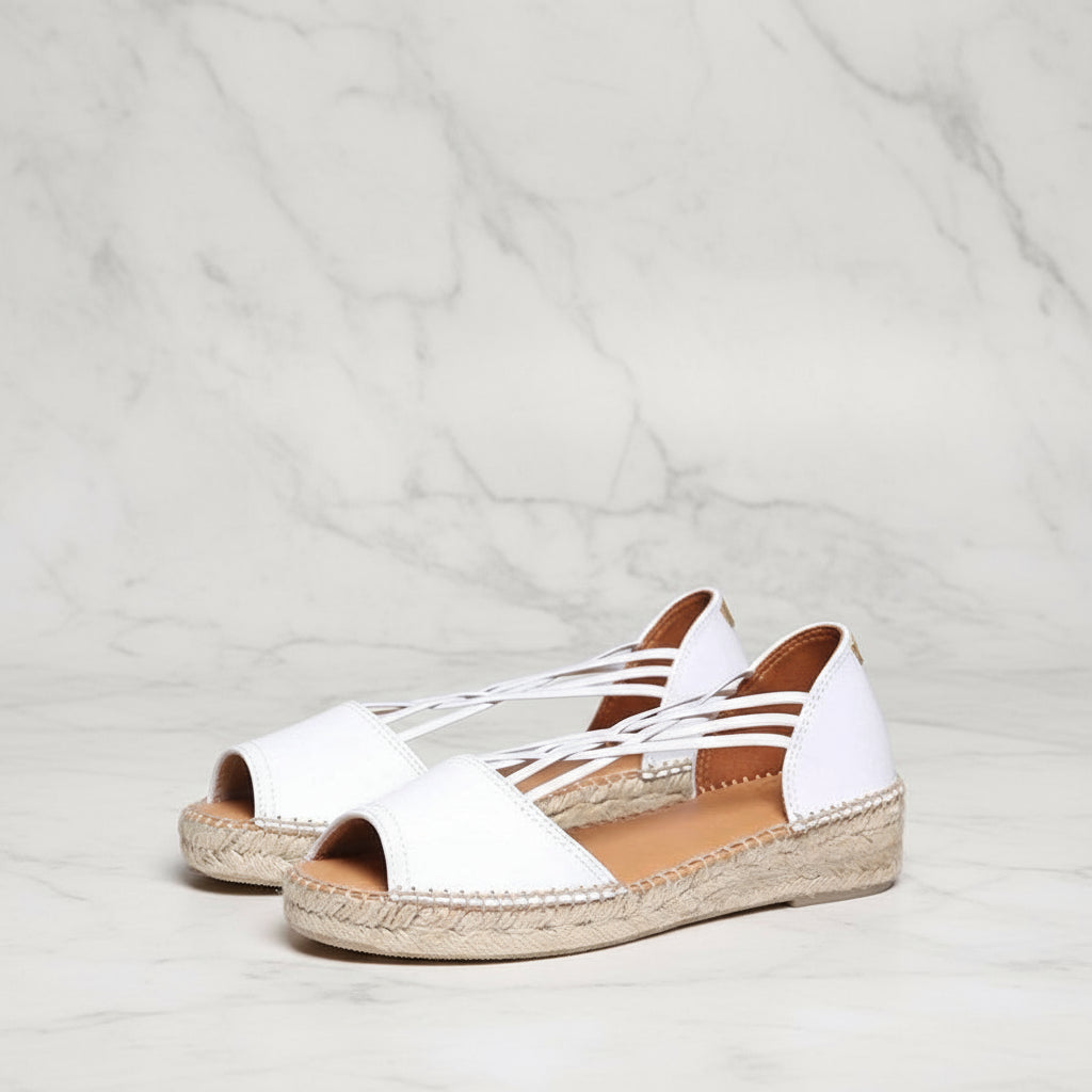 White leather espadrille sandals with peep toe and decorative crisscross straps, featuring handcrafted jute sole for petite feet.