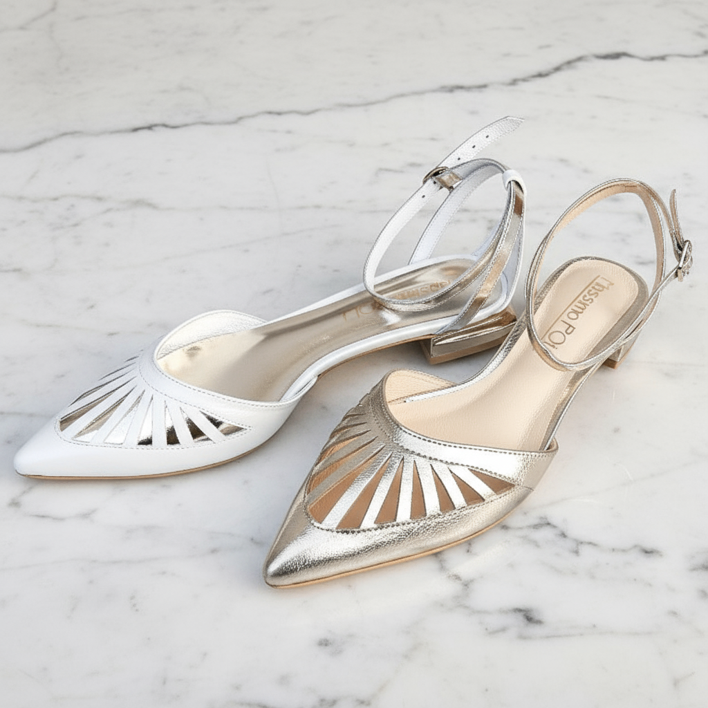 Pair of silver and gold pointed-toe shoes on a marble surface