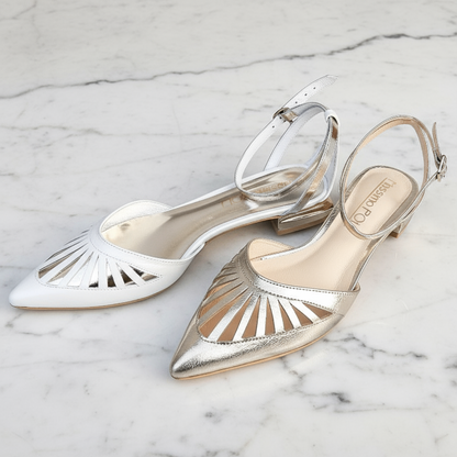 Pair of silver and gold pointed-toe shoes on a marble surface