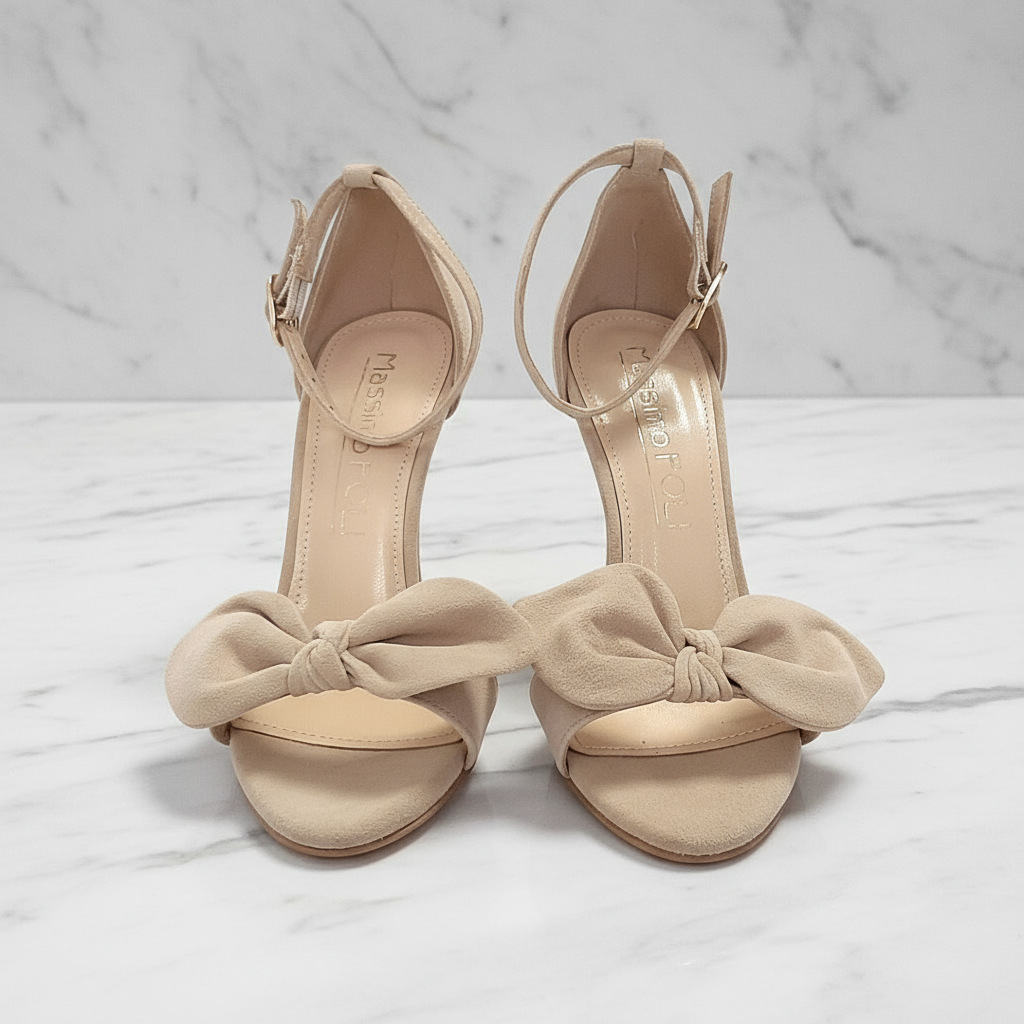 Beige high-heeled sandals with bow details on a white surface