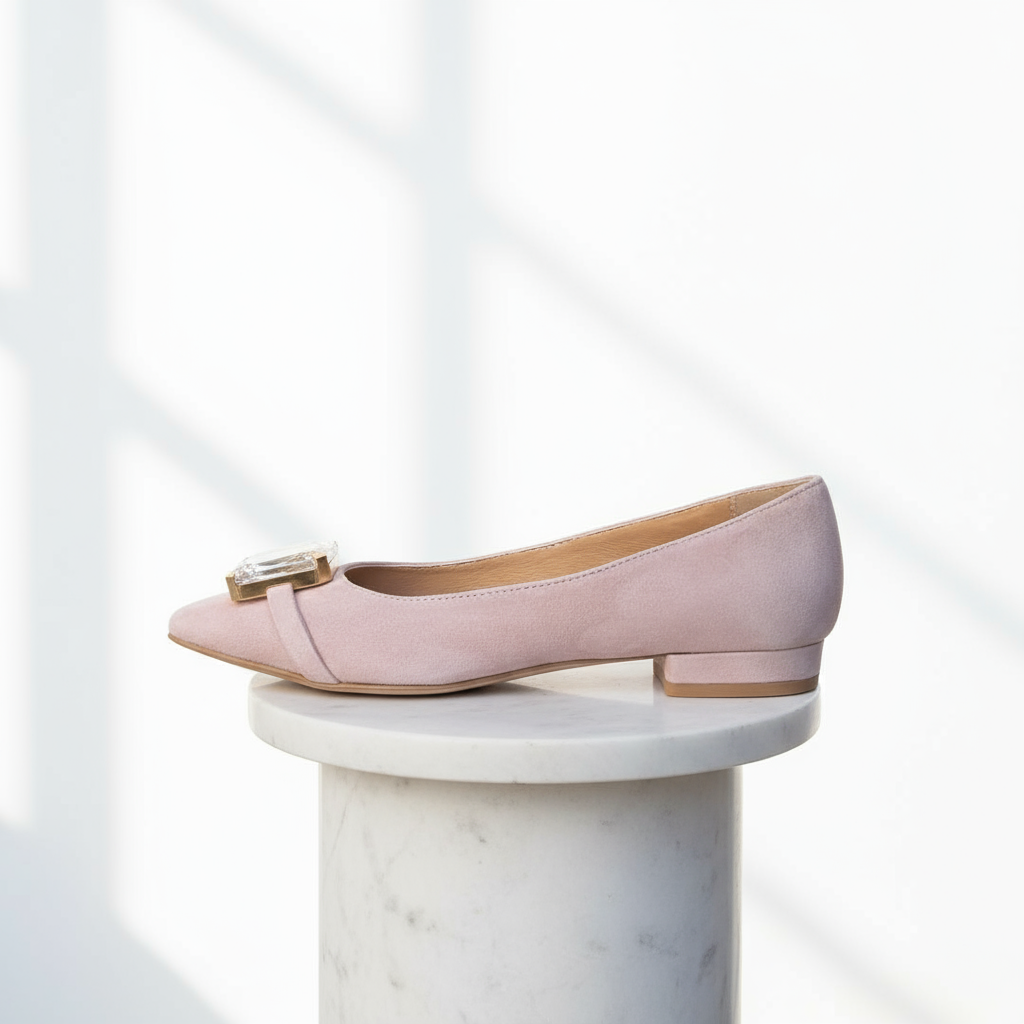 Pink suede shoe with a clear embellishment on a white background