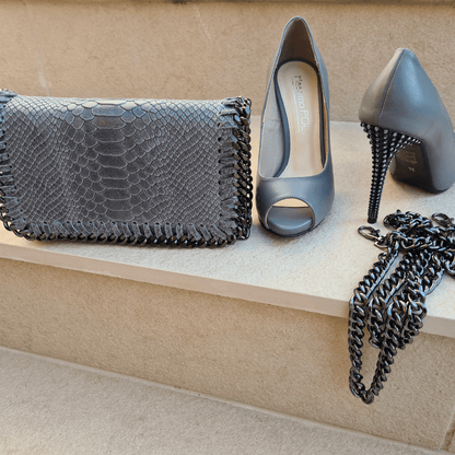 Grey leather clutch bag with a pair of grey high heel court shoes in grey leather