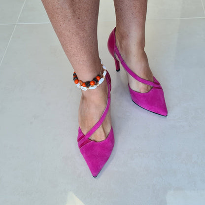 A woman wearing pointed toe court heels in pink leather