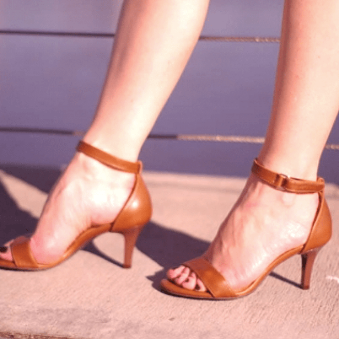 A lady wearing petite size brown leather heeled sandals 