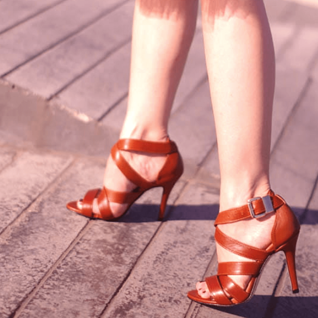 A woman wearing strappy sandals in tan leather
