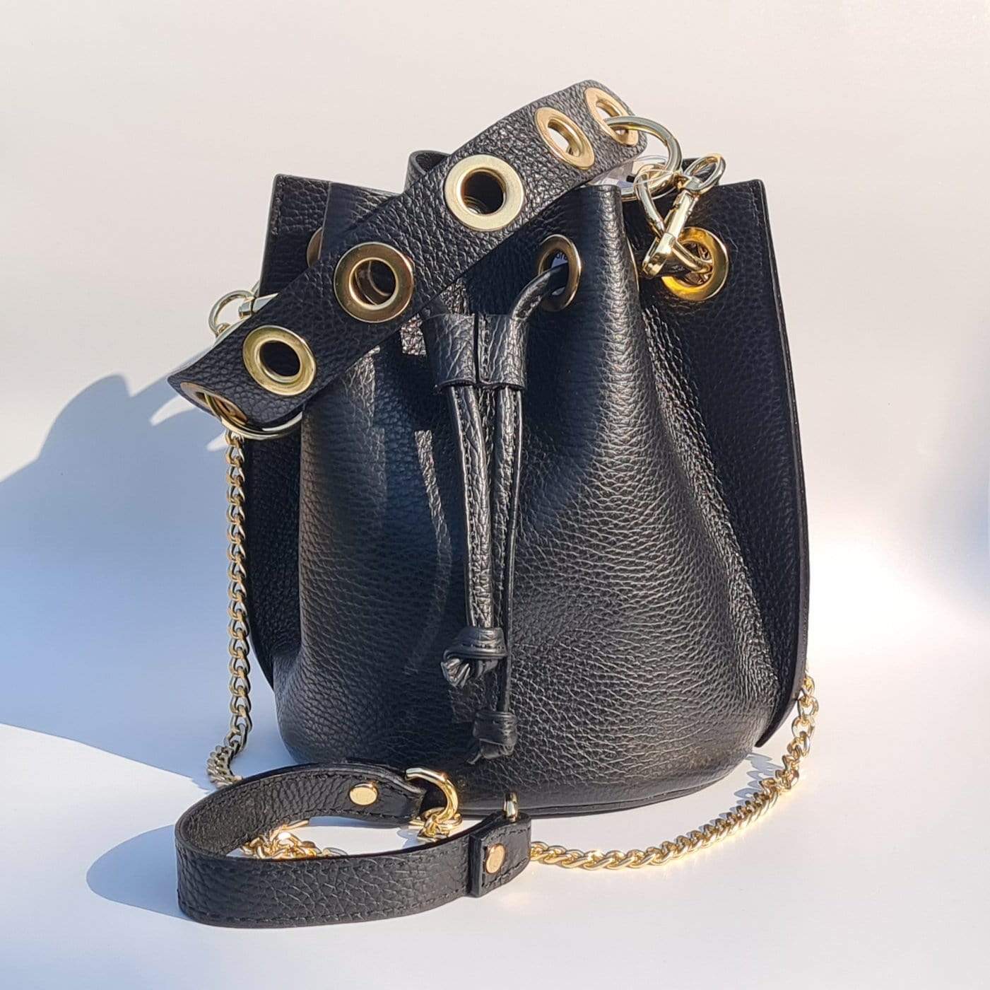 Black leather bucket bag with gold shoulder chain