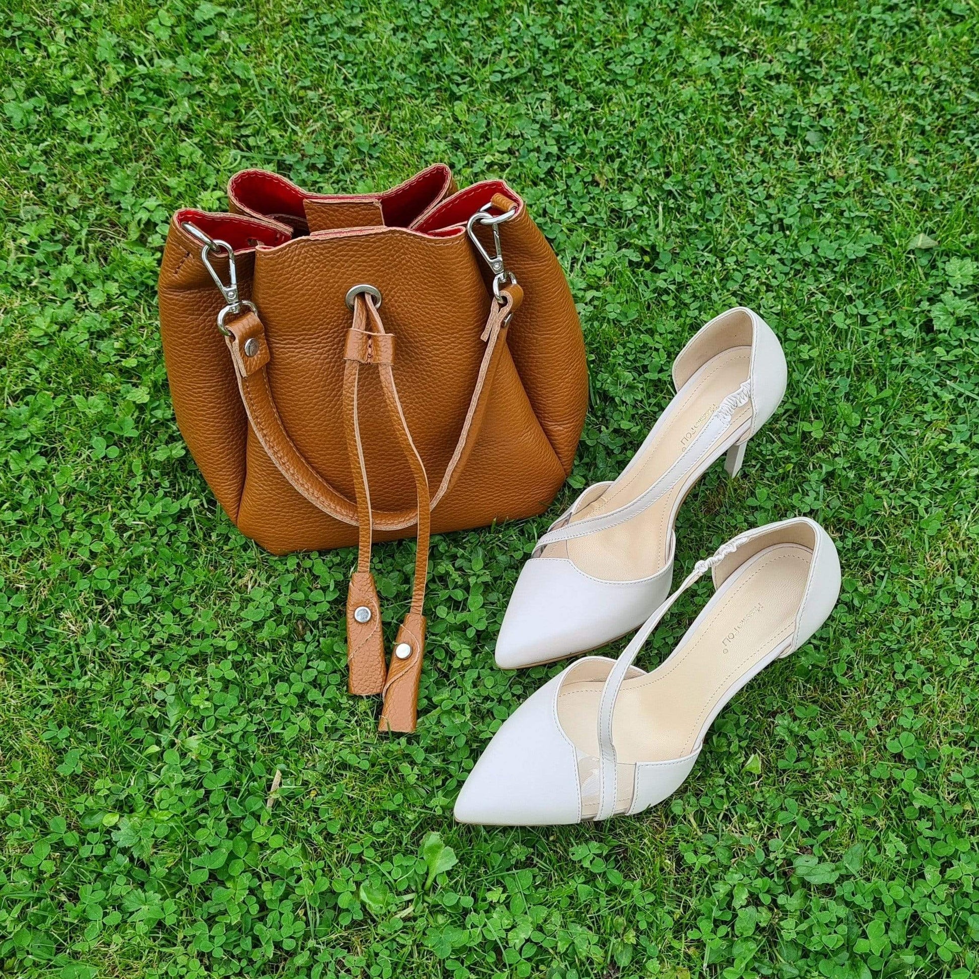 A brown tassel bag with cream court heels 