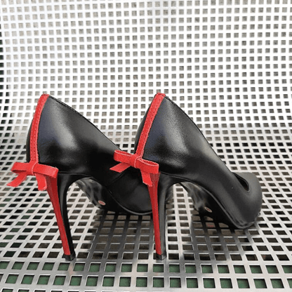 Black leather pointed toe court heels with a red bow